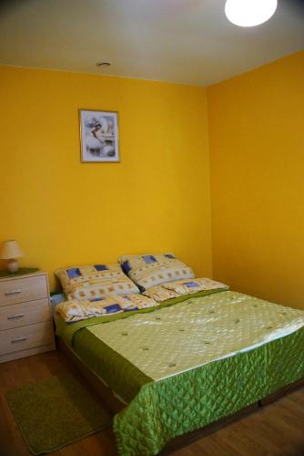 a bedroom with a bed and a yellow wall at Wilcza Chata in Kołczewo