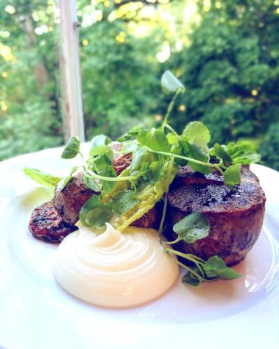a plate of food with meat and greens on it at Husby Säteri in Söderköping