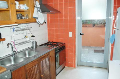 a kitchen with a sink and a stove top oven at One step from the beach, praia da Aguda in Arcozelo