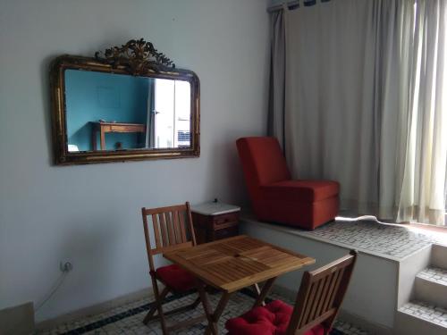 a room with a table and a chair and a mirror at One step from the beach, praia da Aguda in Arcozelo