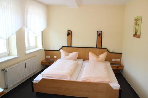 a bedroom with a bed with white sheets and pillows at Pension Weber in Wellen