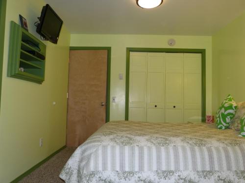 a bedroom with a bed and a tv on the wall at Halcyon Heights B&B/Inn in Homer