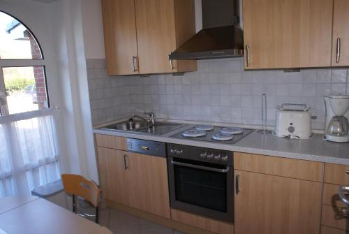 a kitchen with a sink and a stove top oven at Ferienwohnung Tietgens in Hohenfelde