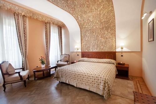 a bedroom with a bed and a chair at Grand Hotel Villa de France in Tangier