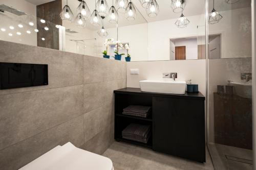 łazienka z umywalką i lustrem w obiekcie Unique 3City Apartments - Grey Apartment w Gdańsku