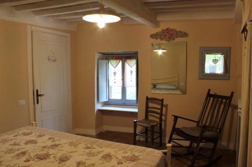 a bedroom with a bed, chair and a window at B&B Paradiso in Gubbio