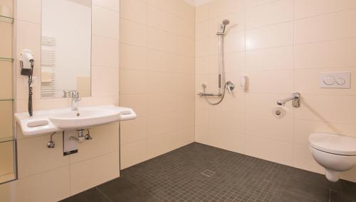 a bathroom with a sink and a toilet at Hotel Johnsburg in Uelzen