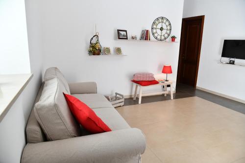 a living room with a couch and a red pillow at Casa Vacanze Il RossAntico in Modica