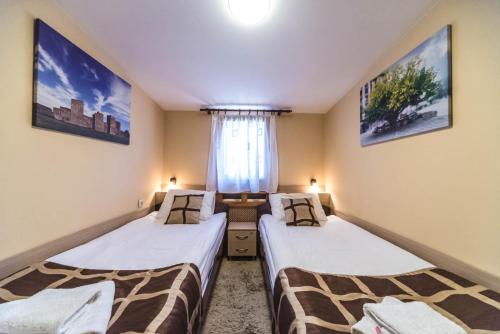 two beds in a room with a window at Talismano Apartments in Smederevo