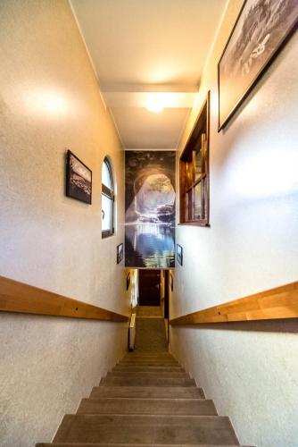 a hallway with stairs and paintings on the walls at Talismano Apartments in Smederevo