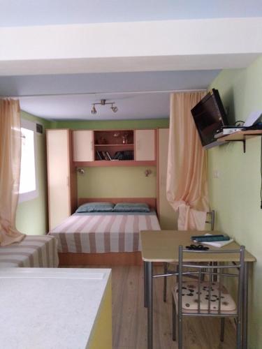 a small room with two beds and a table and a desk at Apartment Ruza in Sali