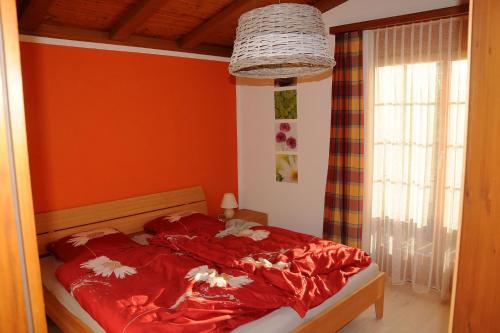 FlumserbergにあるGampergalt - CharmingStayのベッドルーム1室(赤いシーツ付きのベッド1台、窓付)