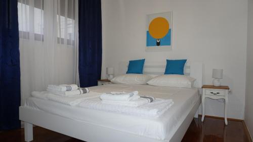 a white bed with towels on top of it at Apartment Sunlight in Mostar