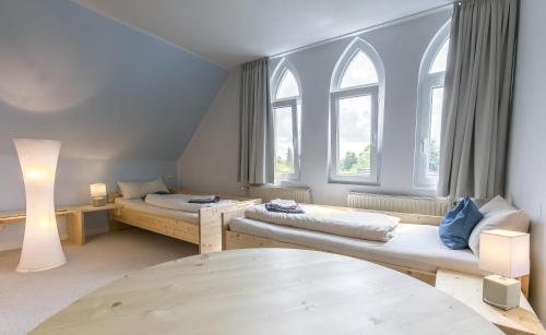 a living room with two beds and two windows at Hotel Johnsburg in Uelzen