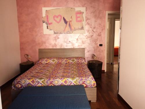 ナポリにあるB&B Smiling Naplesのピンクの壁、ベッド1台付きのベッドルーム1室