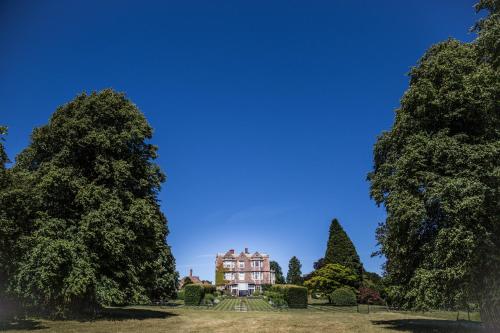 an image of a house between two trees at Goldsborough Hall in Knaresborough