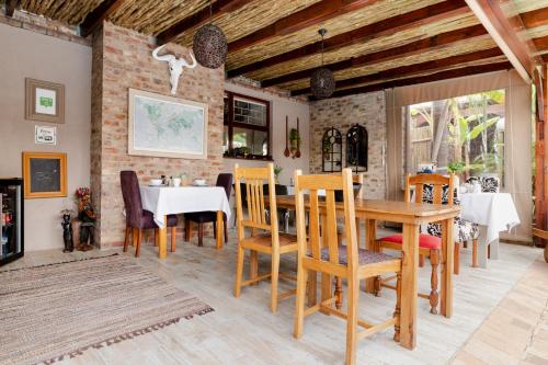 een eetkamer met een tafel en stoelen bij Earthbound Guest House in Oudtshoorn