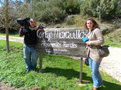 a man and a woman standing next to a sign at Alojamiento Rural Las Maravillas in Cañada Catena