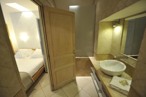 a small bathroom with a sink and a bed at La Bastide du Soleil in Cannes