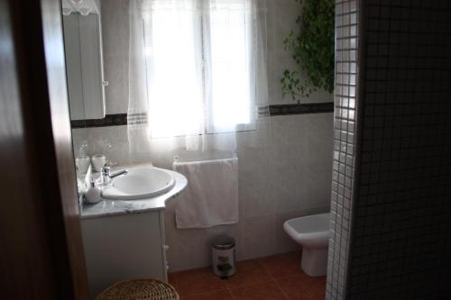 a bathroom with a sink and a toilet and a window at Villa Caramelo in Castril