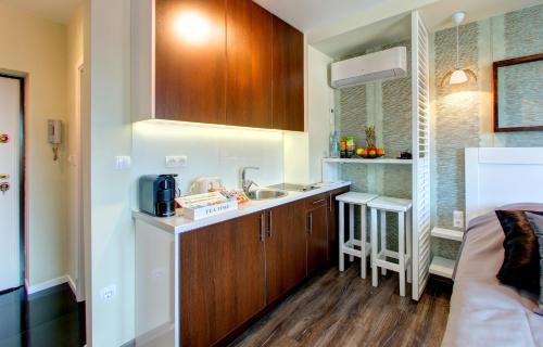a small kitchen with wooden cabinets and a sink at Luxury Studio Yasmine in Mostar