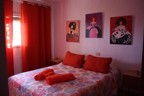 1 dormitorio con 1 cama con 2 almohadas rojas en Villa Caramelo, en Castril