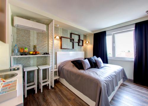 a small bedroom with a bed and a sink at Luxury Studio Yasmine in Mostar