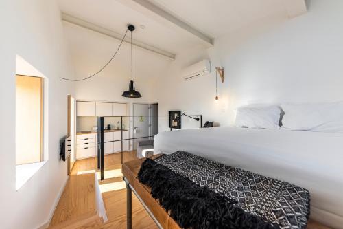 a bedroom with a large white bed and a window at Sapientia Boutique Hotel in Coimbra