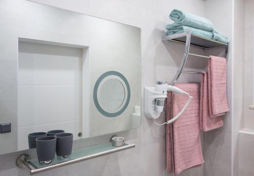 a bathroom with a mirror and pink towels at Apartments Stolfa in Krk