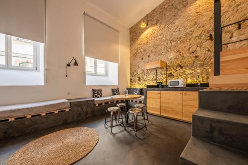 a kitchen with a table and chairs and a large window at Sapientia Boutique Hotel in Coimbra