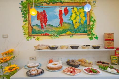 une table avec de nombreuses assiettes de nourriture dessus dans l'établissement B&B Il Girasole, à Agerola