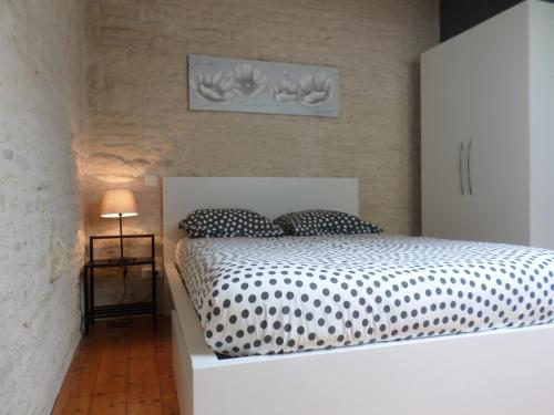 een slaapkamer met een bed met een zwart-wit dekbed bij La Libellule in Coulon