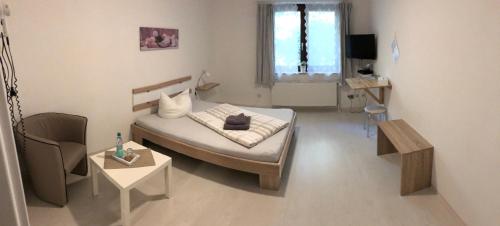 Cette petite chambre comprend un lit et une table. dans l'établissement Hotel am Weißdornbusch, à Gifhorn
