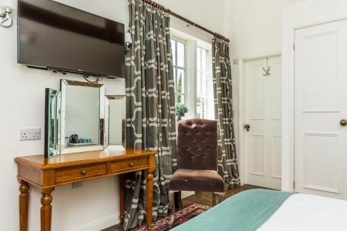 a bedroom with a desk and a mirror and a chair at Tailor Room 2 in Lincoln