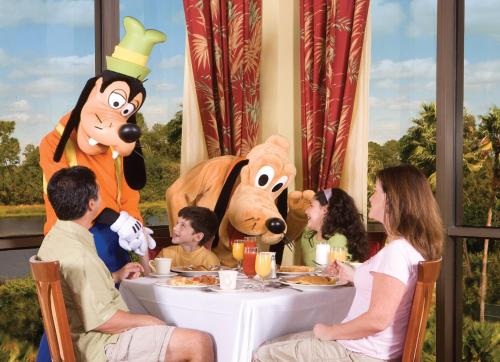 a group of people sitting at a table with mickey mouse at Wyndham Lake Buena Vista – Disney Springs® Area in Orlando