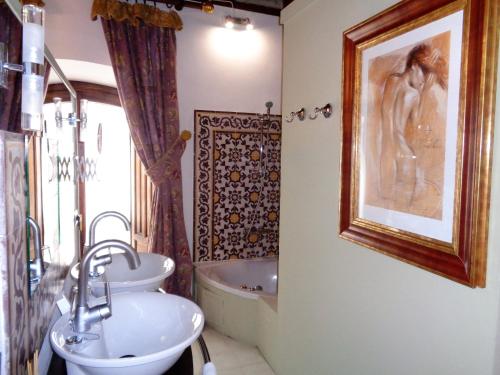 a bathroom with a sink and a toilet and a tub at Hotel Boutique Nueve Leyendas in Úbeda