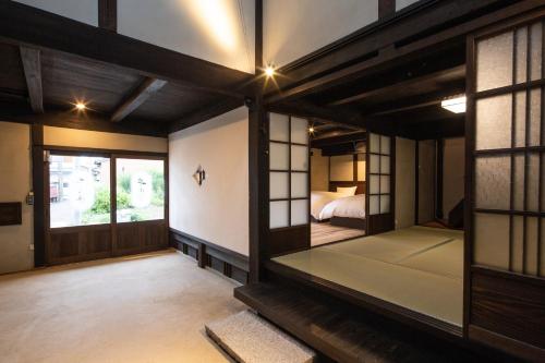 Zimmer mit einem Schlafzimmer mit einem Bett und einem Fenster in der Unterkunft 紀州湯浅古民家町屋宿泊 千山庵 SenzanAn かじやまち301 in Yuasa
