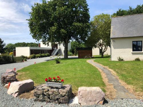 a garden with rocks and flowers in a yard at Hôtel Le Trécelin in Frehel