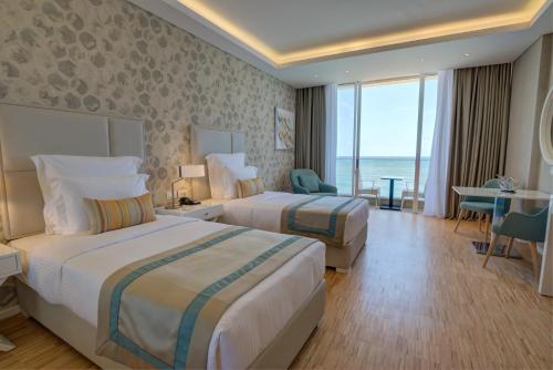 a hotel room with two beds and a view of the ocean at Lancaster Eden Bay in Beirut