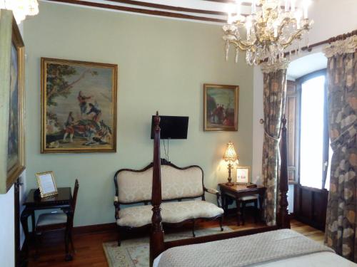 a bedroom with a bed and a chair and a chandelier at Hotel Boutique Nueve Leyendas in Úbeda