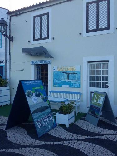 a white building with two signs in front of it at Alojamento Bela Vista in Lajes do Pico