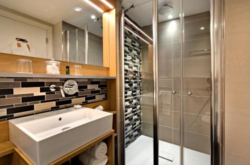 a bathroom with a sink and a shower at Jardins de Mademoiselle Hôtel & Spa in Paris