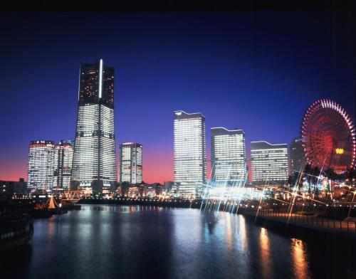 una skyline della città di notte con ruota panoramica in acqua di Yokohama Royal Park Hotel a Yokohama