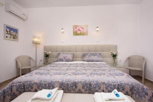 a bedroom with a large bed and two chairs at Romantic Palace Beach Apartments in Agios Gordios