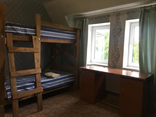 a bedroom with a bunk bed and a desk and a bunk bed gmaxwell gmaxwell gmaxwell at Хостел Благо in Khmelʼnytsʼkyy