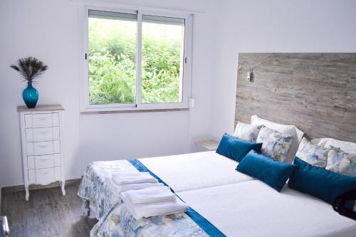 um quarto com uma cama com almofadas azuis e uma janela em Belém River Apartment II em Lisboa