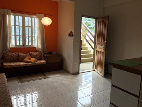 a living room with a couch and a sliding glass door at Charmoso com Sauna e Piscina in Penedo