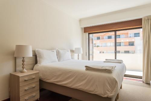 カスカイスにあるFLH Cascais Rooftop Apartmentの白いベッドルーム(大型ベッド1台、窓付)
