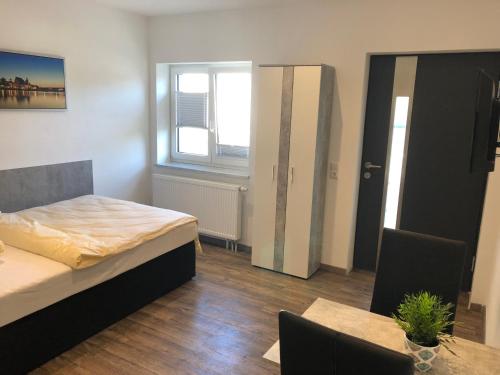 Schlafzimmer mit einem Bett, einem Tisch und einem Fenster in der Unterkunft Hecht Apartments in Mallersdorf-Pfaffenberg