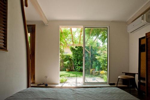 um quarto com uma cama e uma grande porta de vidro deslizante em Le Cabanon de Monte-Carlo avec Jardin Privé em Monte Carlo